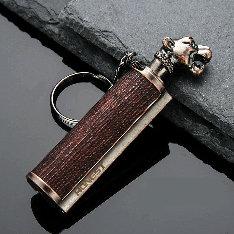 vintage-style metal lighter with wooden texture and lion head keychain on dark stone and reflective surface
