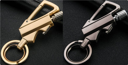 Gold and gunmetal metal keychain lighters with carabiner clips on black textured surface