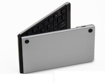 Foldable silver Bluetooth keyboard with black keys, ultra-thin portable wireless design