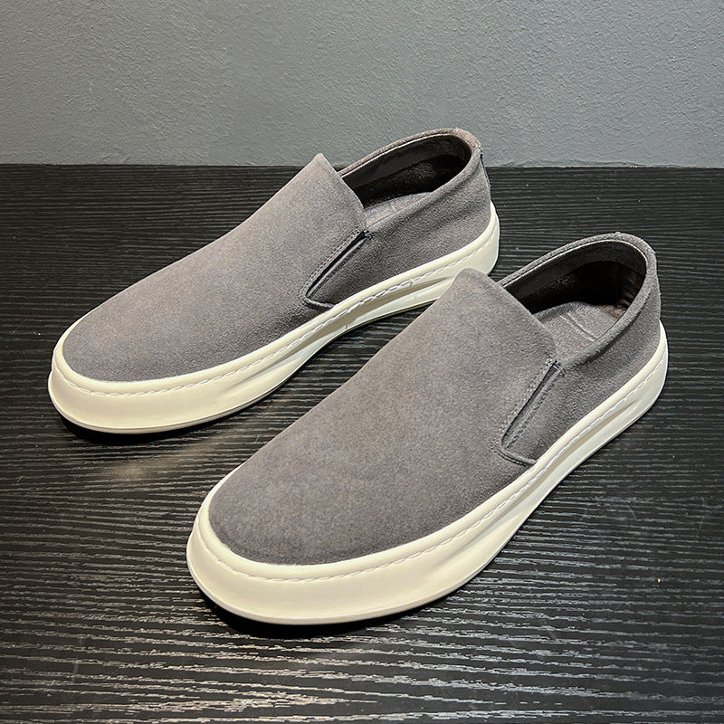 Gray men's casual slip-on shoes with white sole on black textured surface