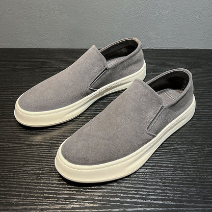 Gray men's casual slip-on shoes with white sole on black textured surface