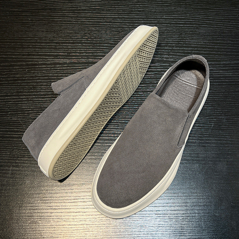 Men's casual gray slip-on shoes with white soles on black wood surface, comfortable loafers