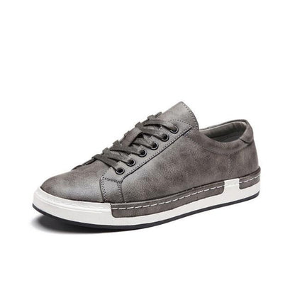 Gray men's leather sneaker with lace-up design and durable white rubber sole