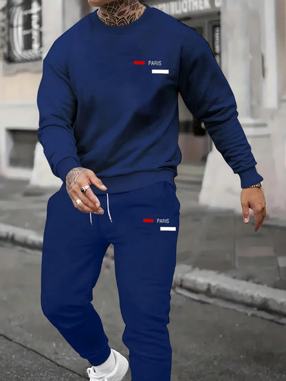 Man wearing navy blue Paris printed sweatshirt and joggers in urban street setting