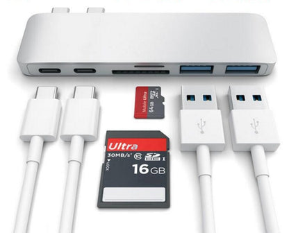 Gray USB-C hub with SD, TF card slots and multiple USB ports alongside USB-C cables and SD cards