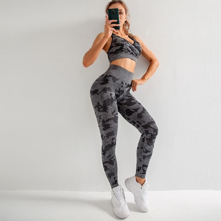 Woman in gray black camo seamless sports bra and leggings activewear set, white sneakers, taking mirror selfie