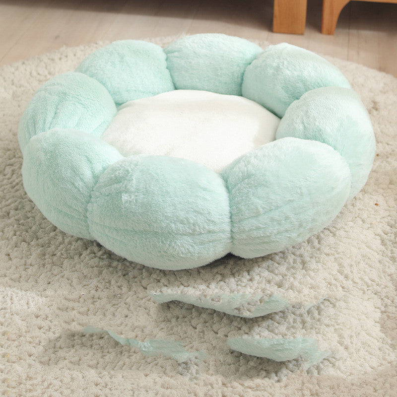 Light green plush flower-shaped pet bed with white center on beige rug