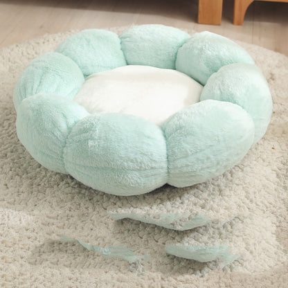 Light green plush flower-shaped pet bed with white center on beige rug