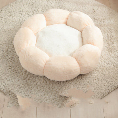 Plush flower-shaped pet bed with soft pale pink petals and white center on beige shaggy rug