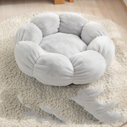 Soft gray flower-shaped plush pet bed on cream textured rug in a cozy room