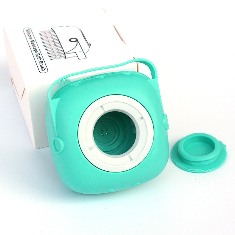 Green round silicone dog bath brush with soft bristles and removable shampoo dispenser next to white box