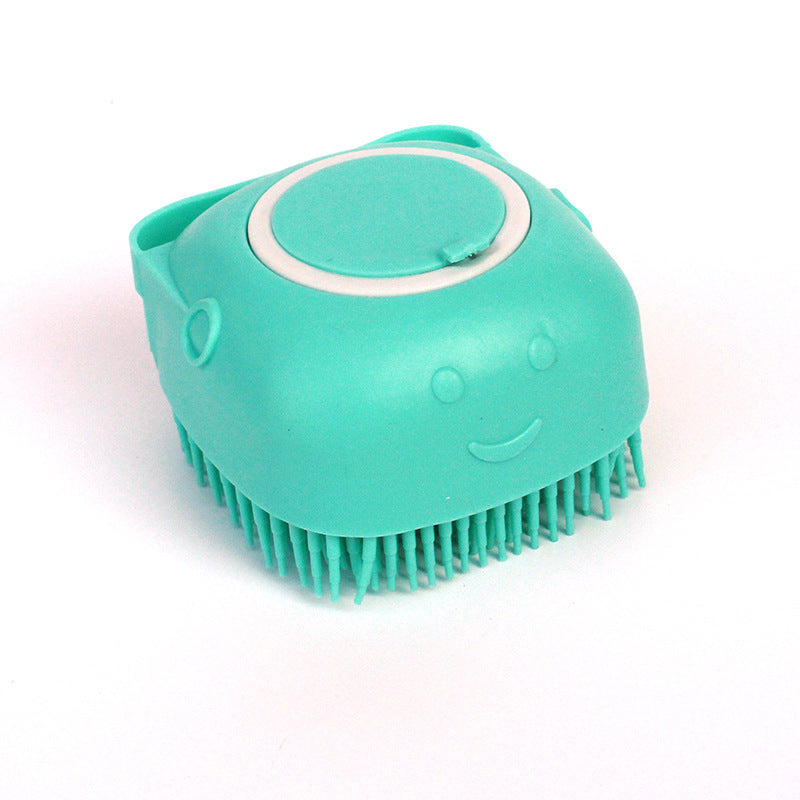 Turquoise silicone dog bath brush with soft bristles and a smiley face design on white background