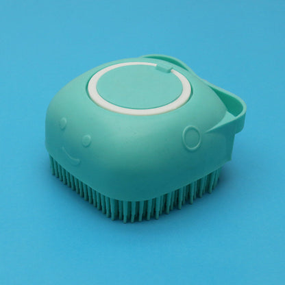 Mint green silicone dog bath brush with soft bristles and smiley face on blue background