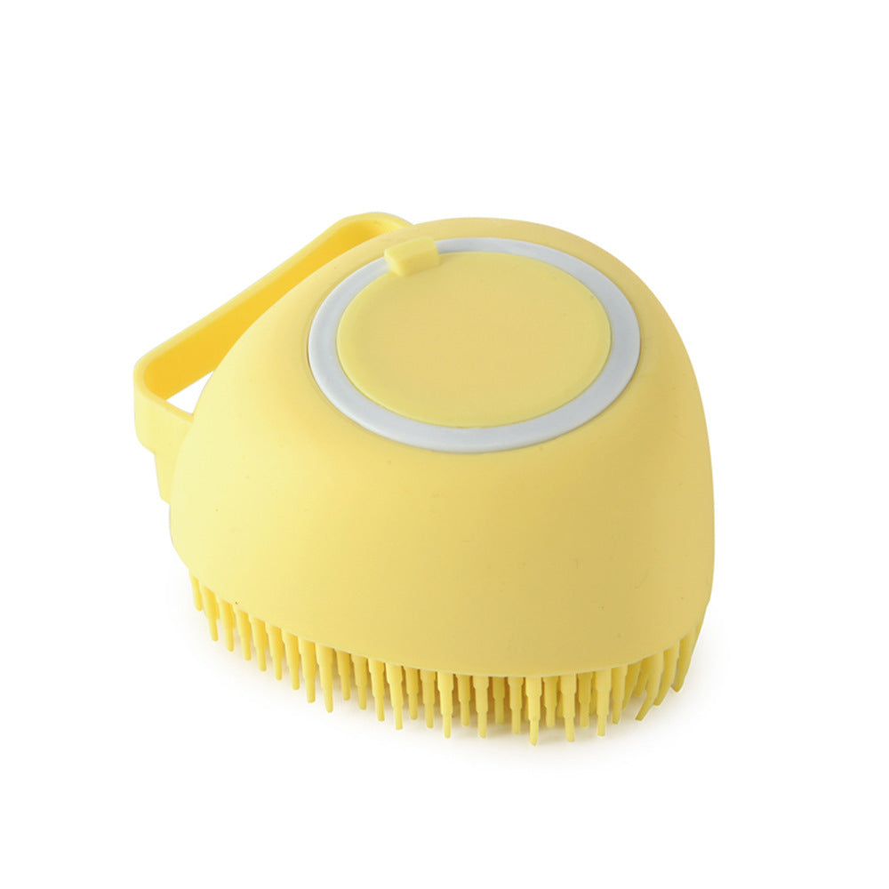 yellow silicone pet grooming brush with soft bristles and handle on white background