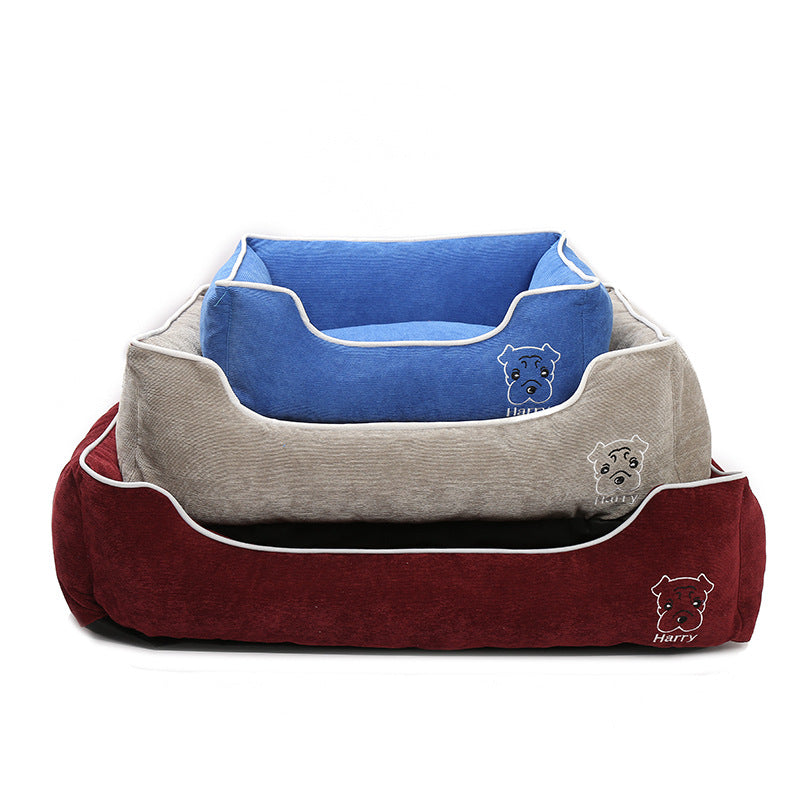 Stacked blue, beige, and red corduroy dog beds with white piping and embroidered dog face designs
