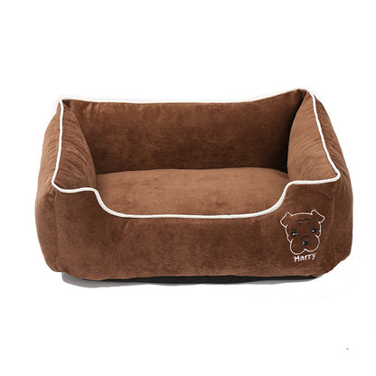 Brown corduroy dog bed with white piping and embroidered dog face on front, cozy pet sofa