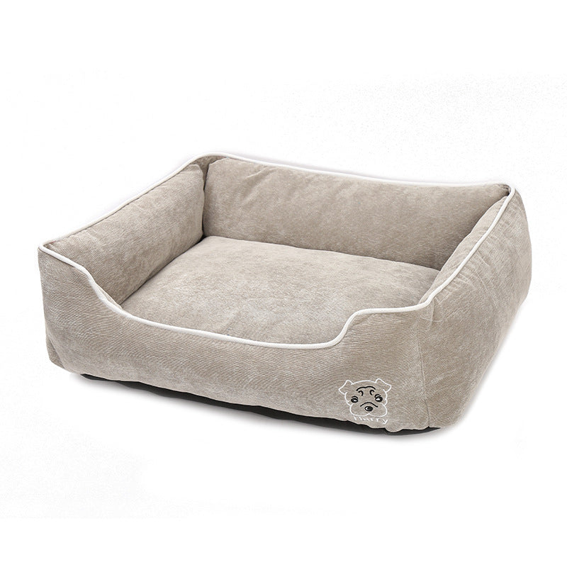 Beige soft corduroy dog bed with raised sides and embroidered dog face on front