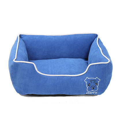 Blue corduroy rectangular dog bed with white trim and dog face embroidery with name Harry