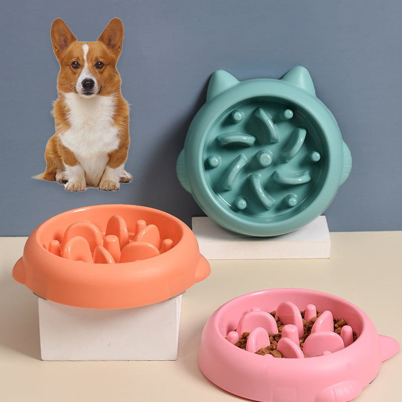 Set of three colorful slow feeder dog bowls with bone-shaped and maze designs, corgi sticker on gray background
