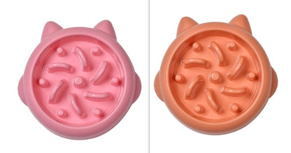 Pink and orange slow feeder cat bowls with raised paw-shaped designs to prevent gulping