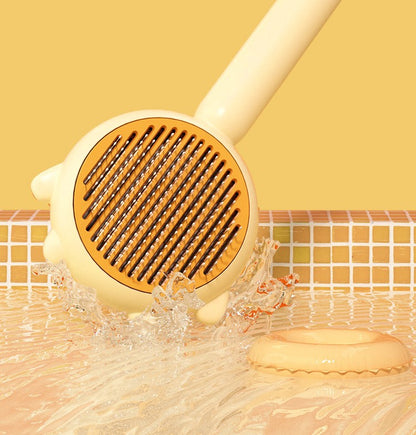 Yellow pet grooming brush with metal teeth splashing water on tiled surface with matching yellow background