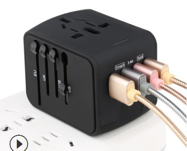 Black universal travel adapter with USB ports and multiple plug sliders connected to an outlet