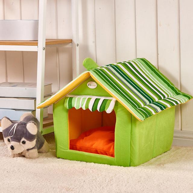 green striped folding pet house with removable cover and orange cushion on beige carpet