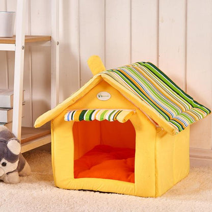 Yellow foldable pet house with green striped roof and orange cushion on carpet