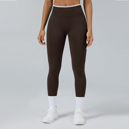 Front view of woman wearing seamless dark brown high-waist workout leggings with white sneakers and socks