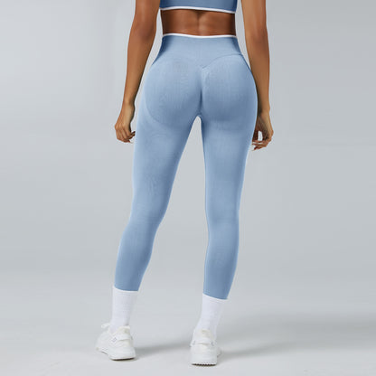 Back view of woman wearing seamless light blue high-waist workout leggings and white sneakers on gray background