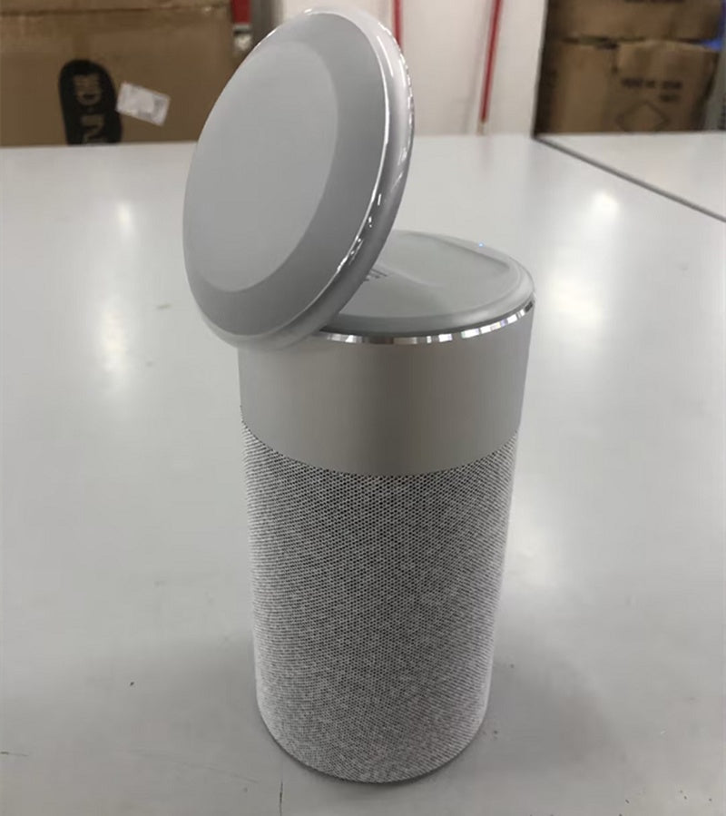 Modern grey wireless Bluetooth speaker with a rechargeable lid on a white surface
