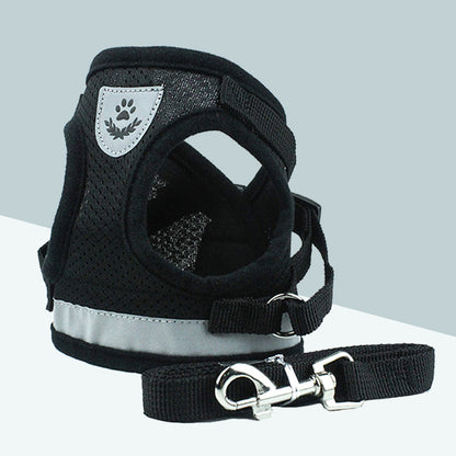 Black breathable dog harness with reflective mesh and metal hardware leash on a gray background