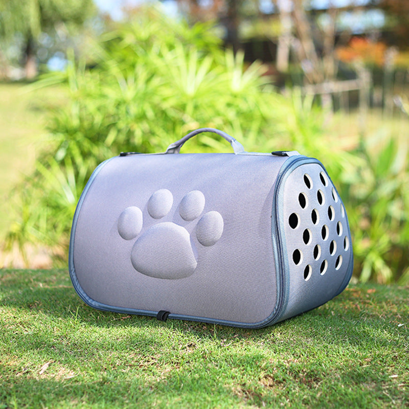 Gray large foldable pet carrier with embossed paw print and ventilation holes on grass outdoors