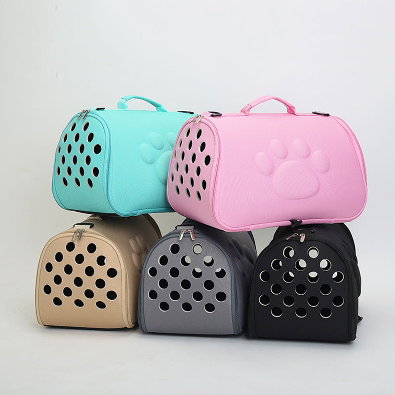 Stack of five foldable pet carrier bags in pastel pink, teal, beige, gray, and black with paw print design and ventilation holes