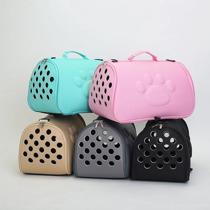 Stack of five foldable pet carrier bags in pastel pink, teal, beige, gray, and black with paw print design and ventilation holes