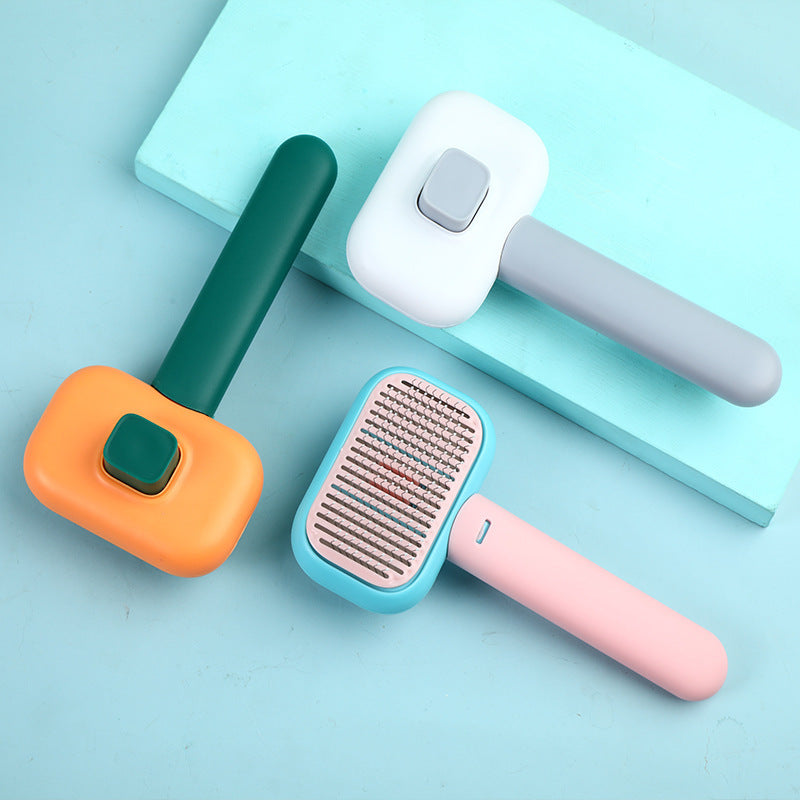 Three colorful pet grooming brushes with ergonomic handles on a light blue surface