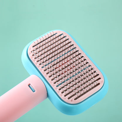 pink and blue ergonomic pet grooming brush with metal pins on teal background