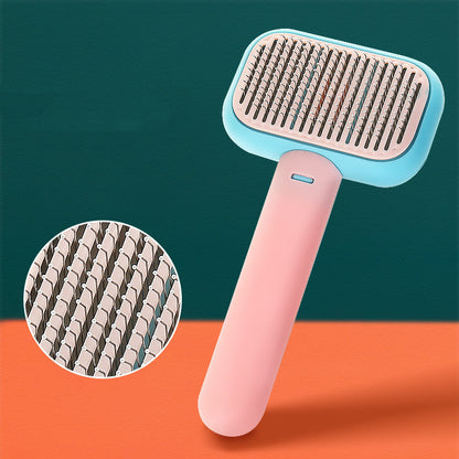 Pink and blue ergonomic pet grooming brush with detailed close-up of flexible metal bristles on orange surface