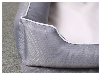 Close-up of dark grey dog bed with honeycomb pattern and white removable cover on grey carpet