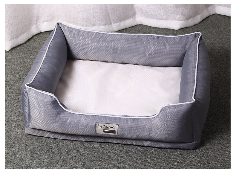 Dark grey removable dog bed with white inner cushion on grey carpet under white curtain