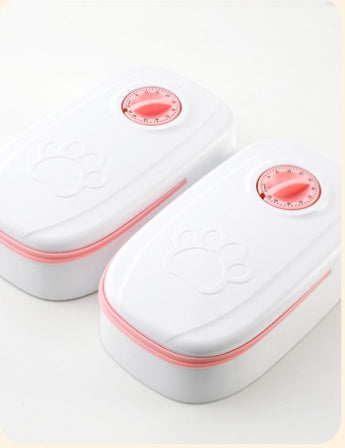 White automatic dual meal pet feeder with pink timer dials and paw print design