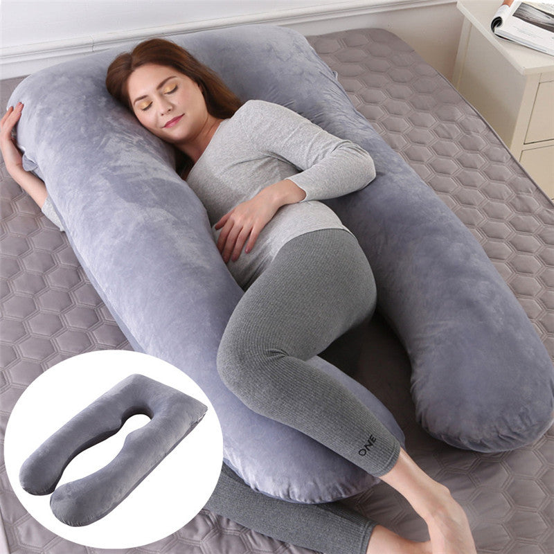 Woman lying on bed using large grey U-shape maternity pillow with cooling silk cover for pregnancy support