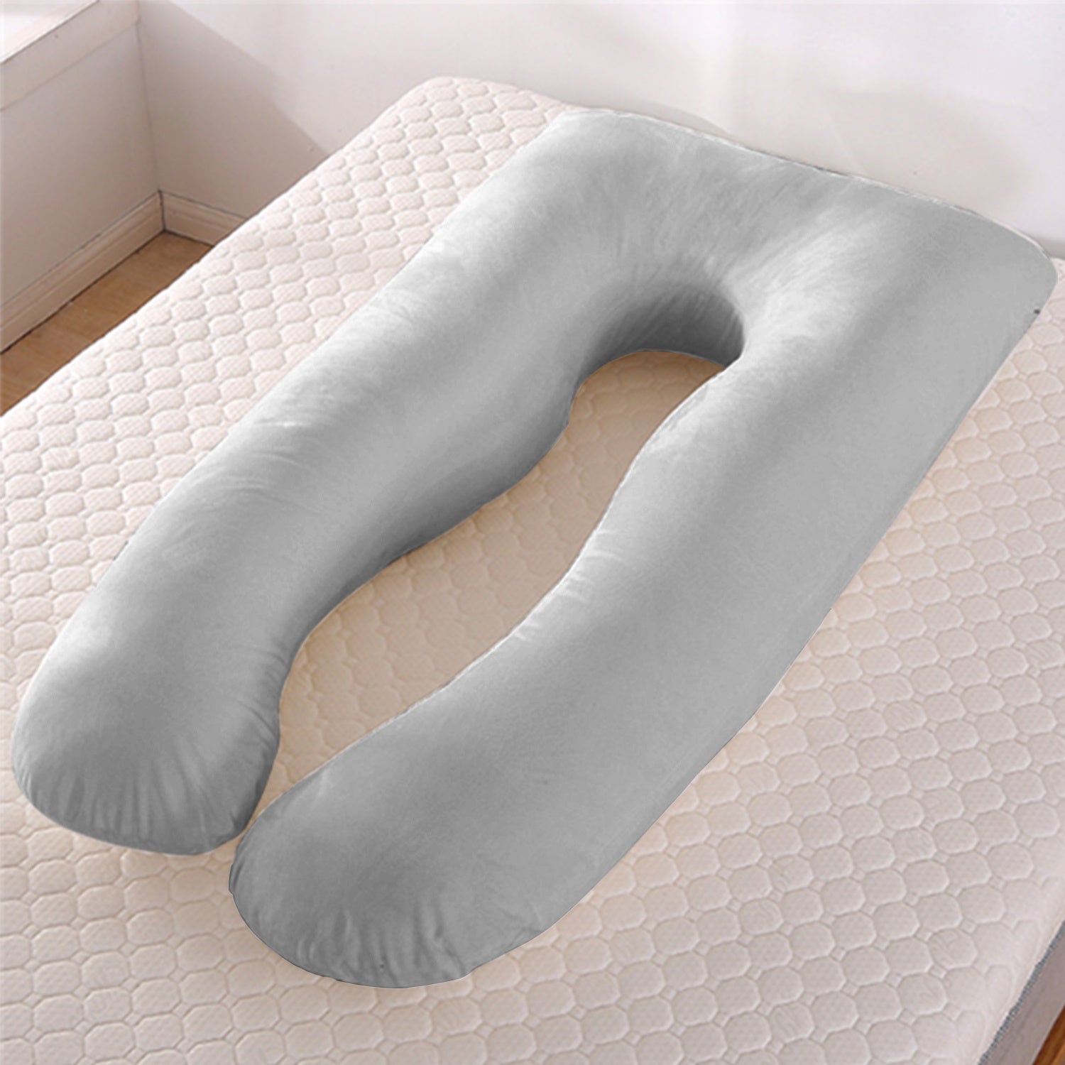 Grey U-shape maternity pillow with cooling ice silk cover on mattress in bedroom corner