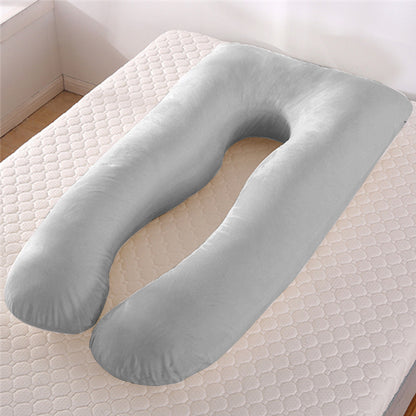 Grey U-shape maternity pillow with cooling ice silk cover on mattress in bedroom corner