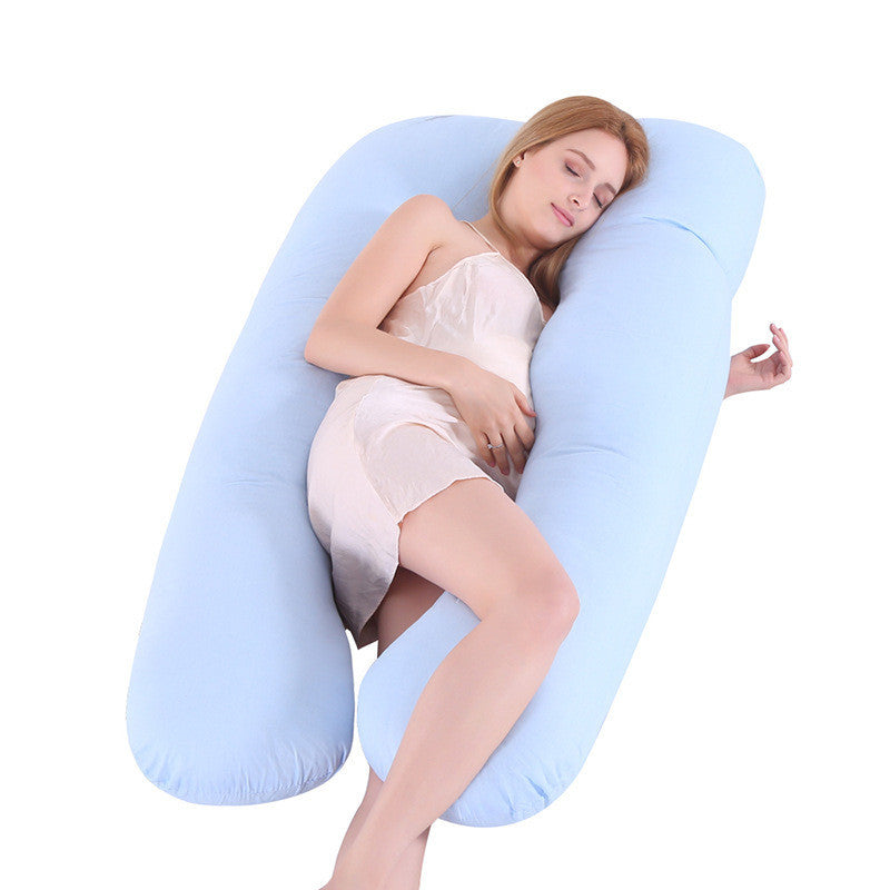 Woman lying and sleeping on light blue U-shape maternity pregnancy support pillow