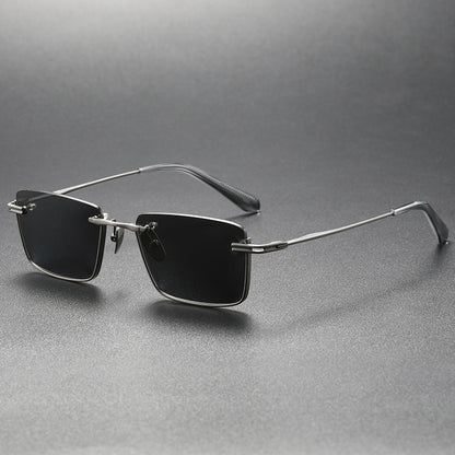 Black and gray rimless rectangular polarized sunglasses with silver metal frame on gray surface