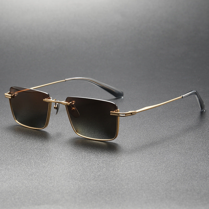 Black and gray polarized square sunglasses with gold metal frame and black temple tips on gray background