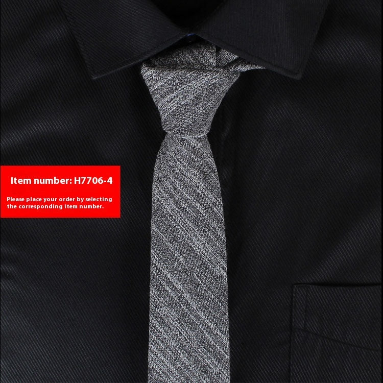 Slim grey cotton tie with textured pattern on black dress shirt collar and pocket