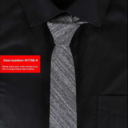Slim grey cotton tie with textured pattern on black dress shirt collar and pocket