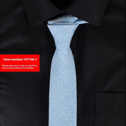 Light blue slim cotton tie with subtle texture on black dress shirt for business or wedding